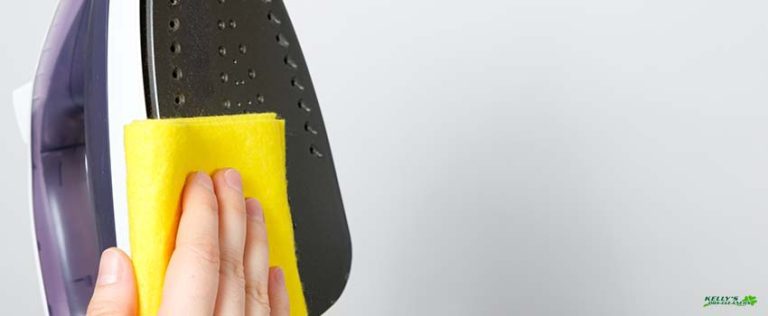 JSP-The housewife wipes the dirty surface of the iron with a yellow rag